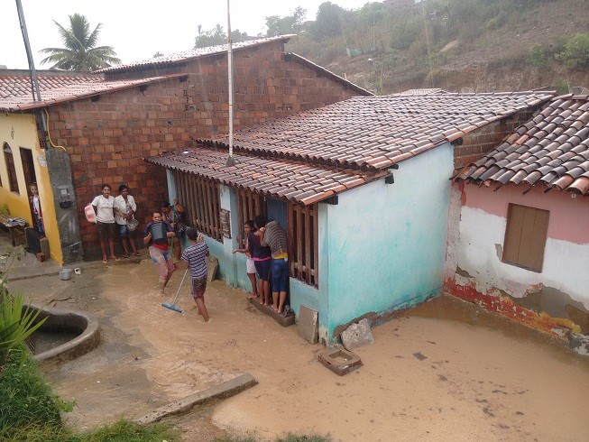 Moradores tentam livrar casas da água da chuva